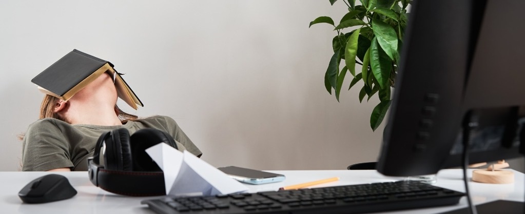 vrouw achter bureau met boek op jaar hoofd denkt aan ontslag