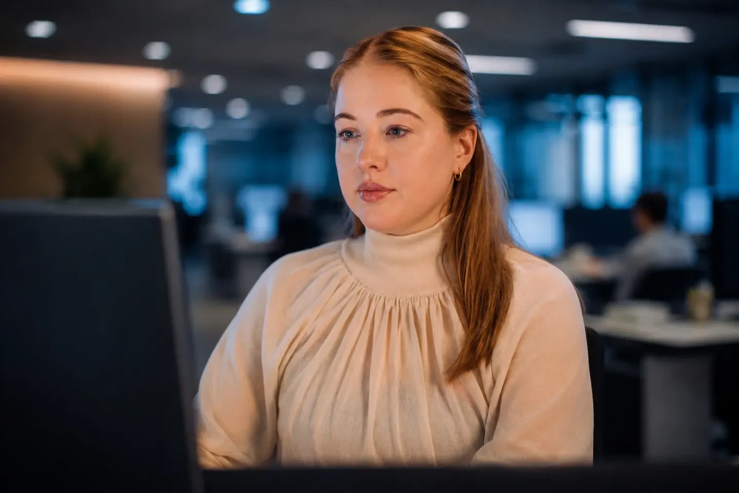 Vrouw-achter-laptop Vrouw werkt achter haar laptop op kantoor